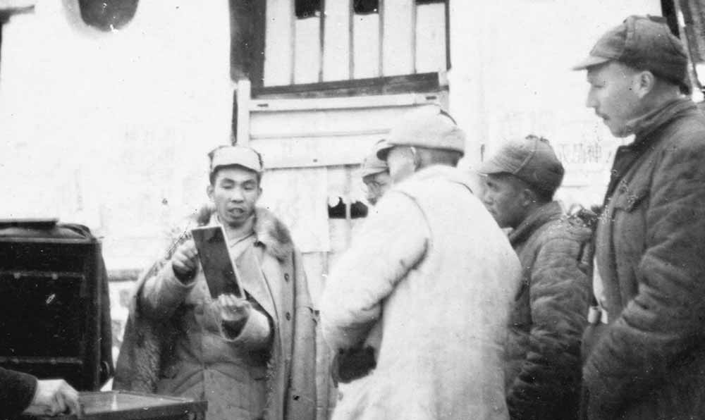 沙飛向參觀者講《晉察冀畫報》的制版情況。